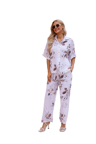 Woman in a floral outfit standing in front of an architectural structure with arches.