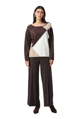 Woman wearing a brown and beige geometric-patterned top with wide-leg pants on a white background