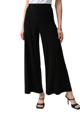 Black wide-leg pants worn by a person on a white background