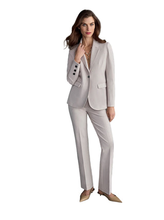 Woman wearing a light gray suit on a dark gray background
