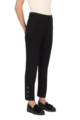 Black pants with button details worn by a person on a white background