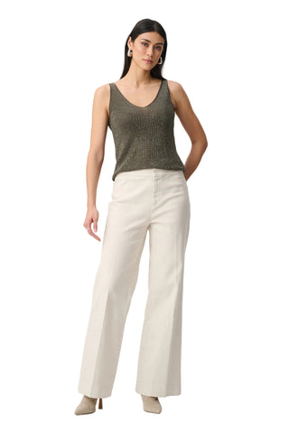 Woman wearing a green sleeveless top and beige pants on a white background