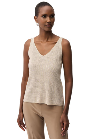 Woman wearing a beige sleeveless top and pants on a white background