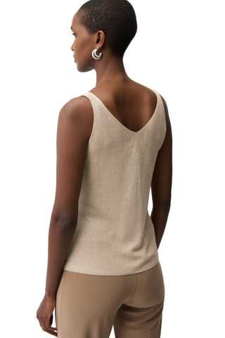 Woman wearing a beige sleeveless top and pants on a white background