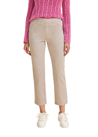 Person wearing beige pants and a pink sweater on a beige background