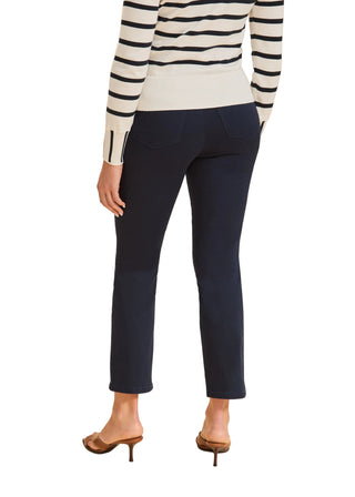 Person wearing navy pants and a striped sweater on a beige background