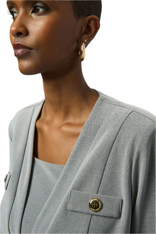 Woman wearing a gray blazer with a close-up of the blazer's pocket button.