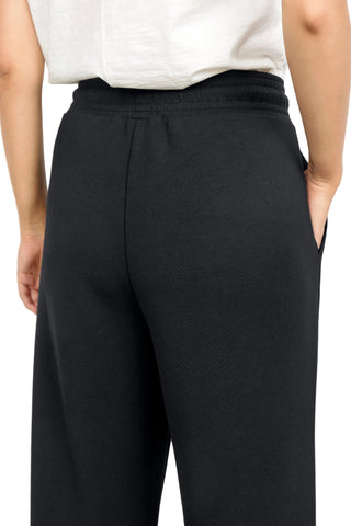 Black pants worn by a person on a white background