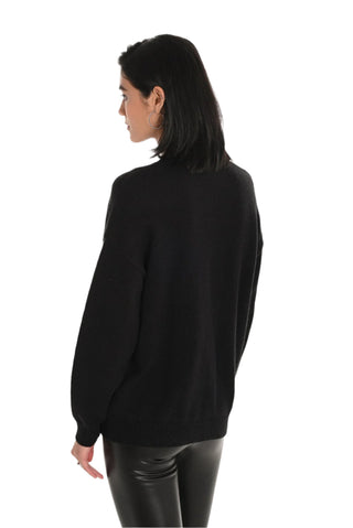 Person wearing a black sweater and black pants on a white background