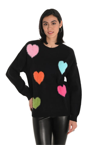 Black sweater with colorful heart patterns worn by a model on a white background