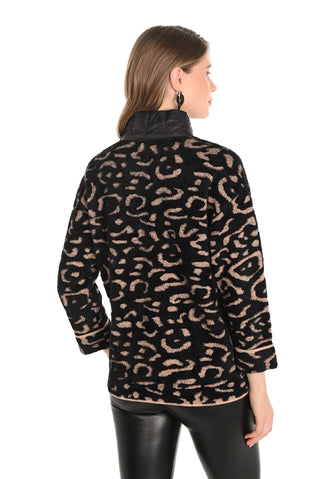 Woman wearing a black jacket with a beige leopard print pattern on a white background