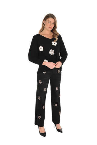 Woman wearing a black outfit with floral embroidery on a white background