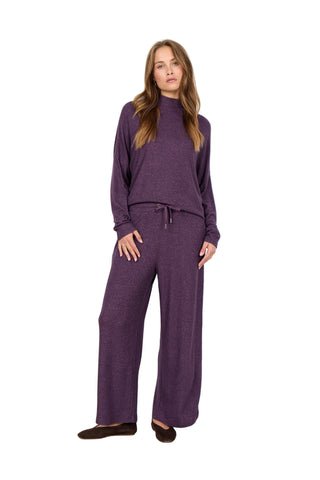 Woman wearing a purple outfit against a white background