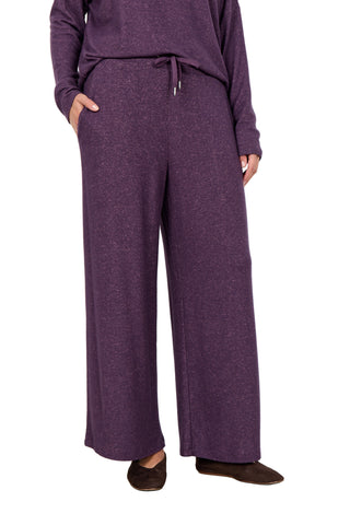 Person wearing a purple outfit with wide-leg pants on a white background