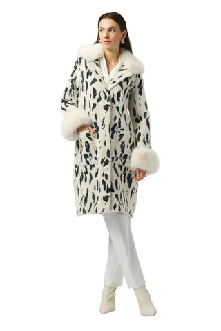 Woman wearing a patterned coat with fur trim on a white background
