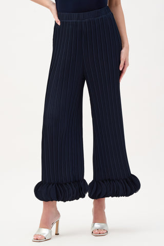 Navy pleated pants with ruffled cuffs on a white background