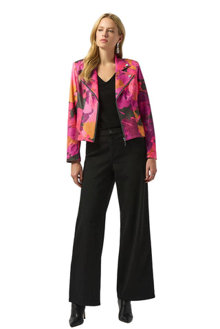 Woman wearing a colorful floral jacket and black pants on a white background
