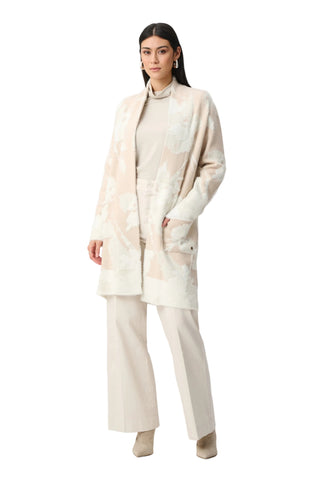 Woman wearing a beige outfit with a matching coat on a white background