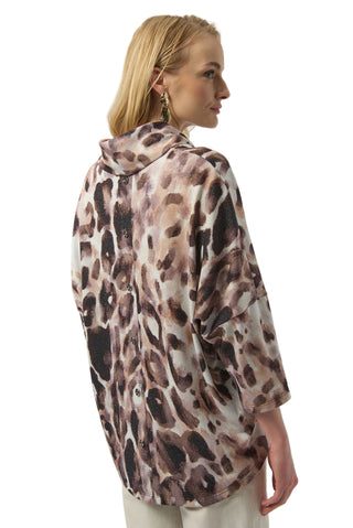 Woman wearing a leopard print shirt against a white background