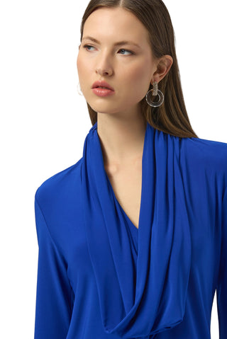 Woman wearing a blue top with a plain background