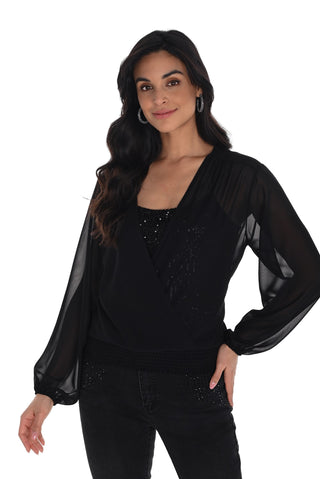 Woman wearing a black blouse with sheer sleeves on a white background
