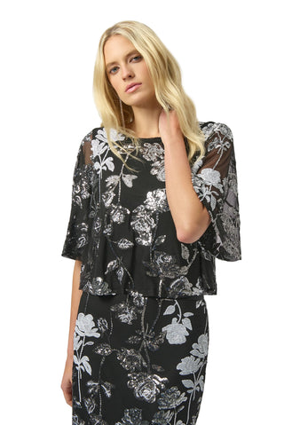Woman wearing a black floral dress against a white background