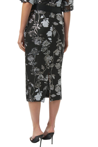 Person wearing a black floral skirt on a white background