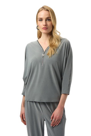 Woman wearing a gray outfit with a zipper detail on a white background