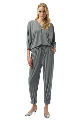 Woman wearing a gray jumpsuit on a white background