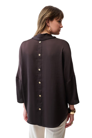 Woman wearing a black blouse with buttons on a white background