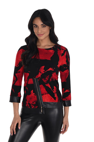 Woman wearing a red and black patterned top with leather accents on a white background