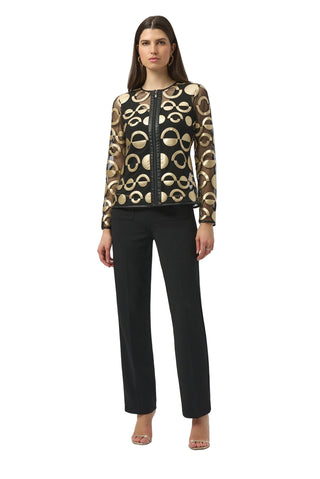 Woman wearing a patterned top and black pants on a white background