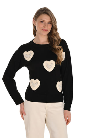 Woman wearing a black sweater with heart patterns on a white background