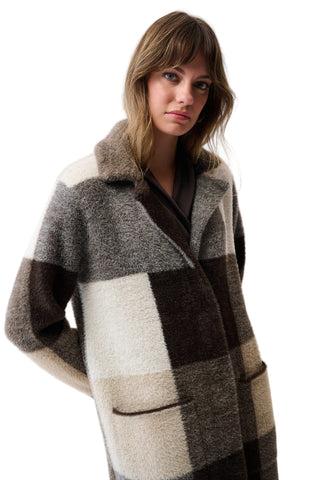 Woman wearing a checkered coat against a white background