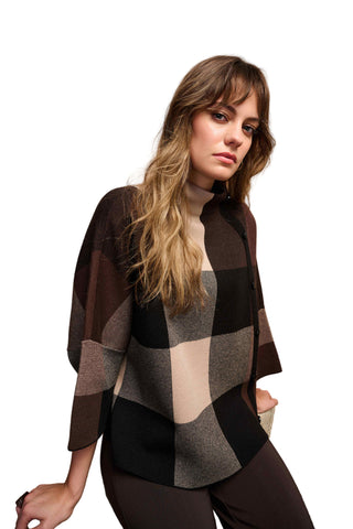 Woman wearing a checkered shirt against a beige background
