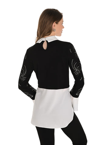 Woman wearing a black and white outfit with intricate designs on sleeves against a white background