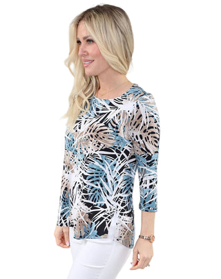 Woman wearing a patterned top with a plain background