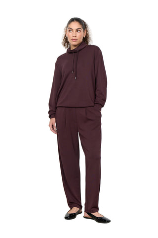 Person wearing a burgundy outfit against a white background