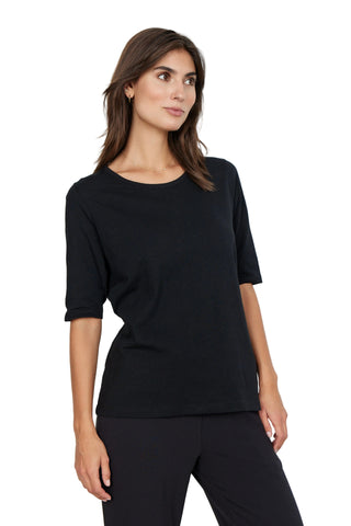 Woman wearing a black top and pants against a white background