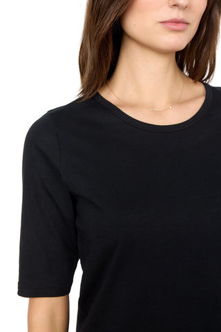 Person wearing a black top with a plain background