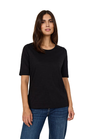 Woman wearing a black t-shirt and blue jeans against a white background