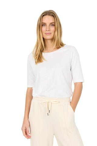 Woman wearing a white top and beige pants on a white background
