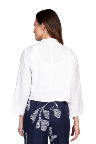 Woman wearing a white blouse and navy pants with white patterns on a light gray background