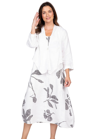 Woman wearing a white kimono-style garment with black leaf patterns on a plain background
