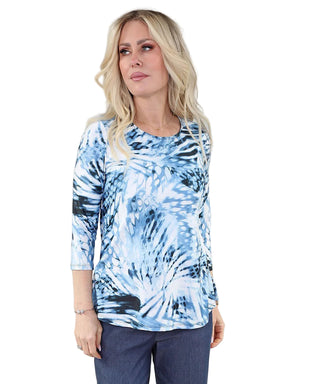 Woman wearing a blue tie-dye shirt against a plain background