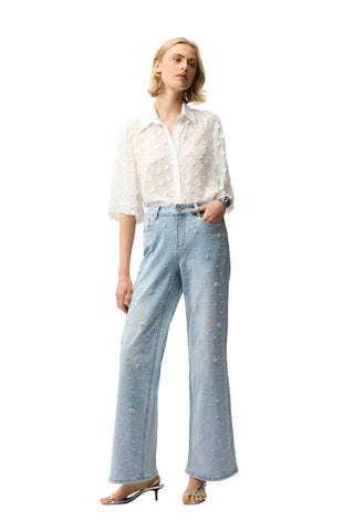 Woman wearing a white blouse and light blue jeans on a white background