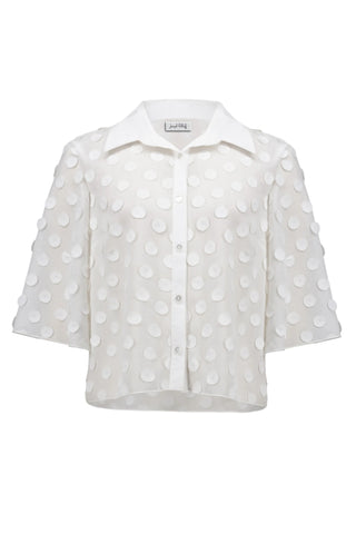 White blouse with polka dot pattern on a white background