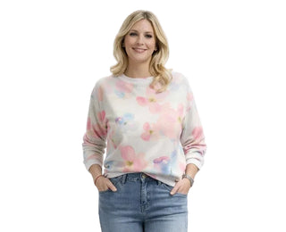 Woman wearing a floral sweater and jeans on a white background