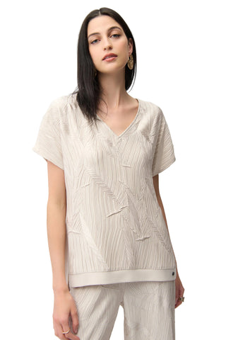 Woman wearing a beige textured top and pants on a white background