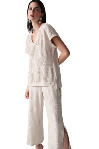 Woman wearing a beige outfit with a plain background